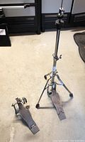 Both the Tama bass drum pedal and single braced hi-hat stand shown together on floor
