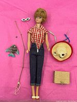 Full view of doll and all accessories arranged on pink background