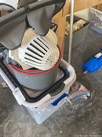 Multiple cleaning buckets stacked on top of each other including a white laundry basket and mop bucket.