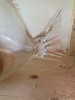 Close-up image showing the tail fin of the clear glass fish-shaped vase with detailed glass contours.