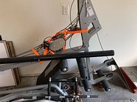 Partially assembled frame with vertical support, seat back, cables, and foam rollers
