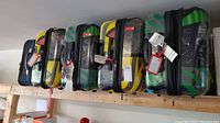 Five suitcases lined up on a wooden shelf showing overall lot composition