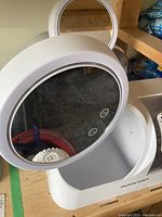 Close-up of a white Joyboss makeup center organizer showing the round LED mirror with touch controls and open storage compartment.