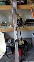 Front view showing a full pair of Rossignol skis with bindings standing against shelf.