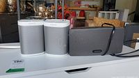 Two white Sonos Play:1 speakers and one gray Sonos Play:3 speaker displayed side by side.