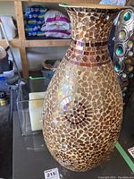 Photo showing the mosaic vase with detailed tile work and circular pattern.