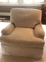 Front view of beige upholstered armchair