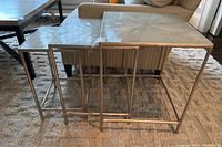Front-angle view of all three tables nested, showing scale and finish