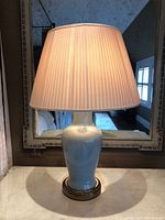 Full view of lamp one showing ceramic body, brass base and pleated shade