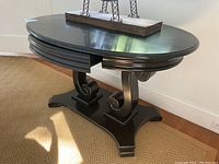 Front left view showing oval top, drawer and scroll pedestal base