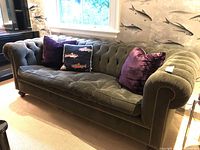Front right angle view of entire tufted corduroy sleeper sofa with throw pillows.