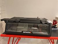 Front view of the Sparx skate sharpener with clear hood and Sparx logo visible