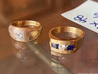 Two rings displayed side by side on glass surface