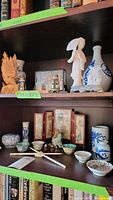 Bookshelf showing top and second shelf of Asian decorative items