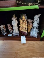 All six carved pieces displayed on wood shelf