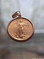 Obverse of coin pendant showing Lady Liberty design, rays and date