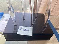 Black rectangular base with five clear glass elongated forms inserted