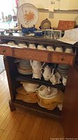 Wide view of assembled china pieces in cabinet.