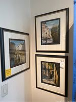 Three framed prints hung on wall