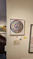 Front view of framed multicolor spiral print by Agam