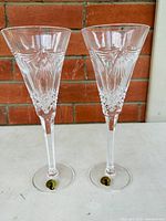 Pair of Waterford crystal toasting flutes with detailed cut crystal design and Regency styling.