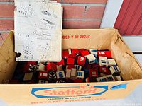 Box of wooden architectural blocks with painted window and door designs, cardboard box labeled 'Stafford'