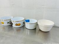 Lot of four ceramic bowls arranged in a line showing two Royal Worcester patterned bowls, one plain Mason Cash bowl, and one additional embossed patterned bowl