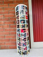 Rolled uncut sheet showing front side with multiple hockey card images in colorful border designs against brick wall background.