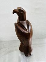 Front-side view of a hand-carved ironwood eagle sculpture showing the detailed head, beak, and wing feathers.