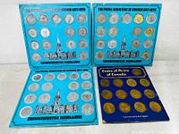 Four blue and one dark blue display folders containing evenly spaced commemorative coins and medallions commemorating Canadian Prime Ministers 1867-1970 and the Coat of Arms of Canada. The coins include silver and gold-toned medallions with portraits and heraldic imagery.