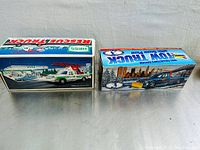 Photo showing the boxed 1994 Hess Toy Rescue Truck and the 1996 Sunoco tow truck boxes side by side, displaying graphics and branding.