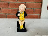 Front view of the Pickwick figurine showing the detailed face, yellow waistcoat, black coat, and black base.