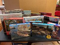 Photo showing 13 sealed puzzle boxes with various images like Big Ben, Venetian canal, and more.