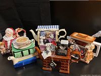 Group shot of six novelty teapots on black surface