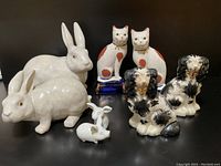 Front view showing all animal figurines including two bunnies, two cats, two spaniel dogs, and two pig figurines.