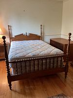 Full view of vintage Ethan Allen double bed frame with mattress on wooden floor next to nightstand and dresser.