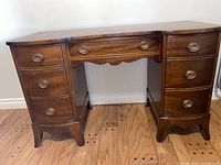 Full front view of antique wooden dressing table showing six drawers on two sides with curved legs and center drawer below table top