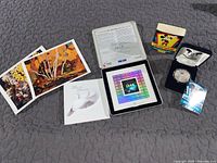 Lot overview showing all items together: Mickey Mouse coin in presentation box, Millennium Keepsake stamp in display case, two Tom Thomson postcards, and an additional white card with a dove image.