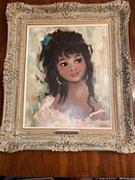 Full view of the framed oil painting depicting a young woman with dark hair and a white dress.