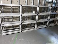 Photo of 4 plastic shelving units arranged side by side against a wall, showing their structure and size.
