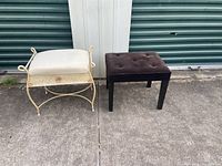 Two benches: one iron frame vanity bench with cream fabric cushion, one brown fabric tufted wooden stool, outdoors in front of storage unit doors.