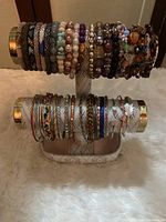 Bracelets displayed on a double-bar stand showcasing various colors and styles, highlighting material variety and condition.