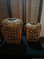 Front view of both woven rattan storage chests showing size difference and latch details