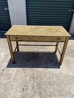 Front view of wooden desk/buffet table showing drawer and leg design.