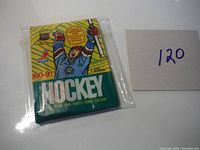 Front view of the unopened 1990-91 OPC hockey card wax pack with original packaging and bright artwork of a hockey goalie holding a stick and puck.