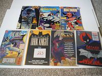 7 Batman comic books in a single image showing front covers with various Batman themed illustrations and titles.