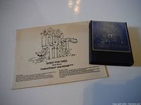 Game cartridge for BC's Quest For Tires with instruction manual showing title and branding for ColecoVision and ADAM systems.