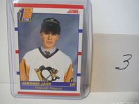 Front side of Jaromir Jagr 1990 rookie card showing player wearing Pittsburgh Penguins jersey and first round draft badge.
