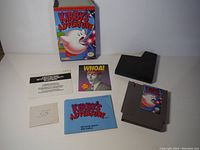 Full set of Kirby's Adventure with game cartridge, instruction booklet, NES booklets, and black styrofoam block.