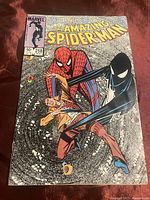 Front cover of The Amazing Spider-Man 258 issue showing Spider-Man and alien symbiote character in classic comic art style. Marvel Comics logo, issue number, price, and date visible.